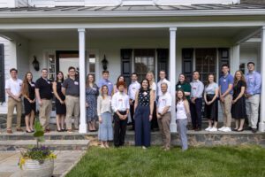 A group of associates standing on steps in a house
